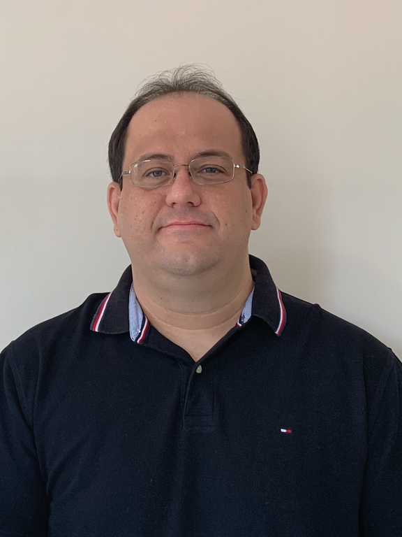 White man with short straight brown hair, wearing glasses and a black polo shirt