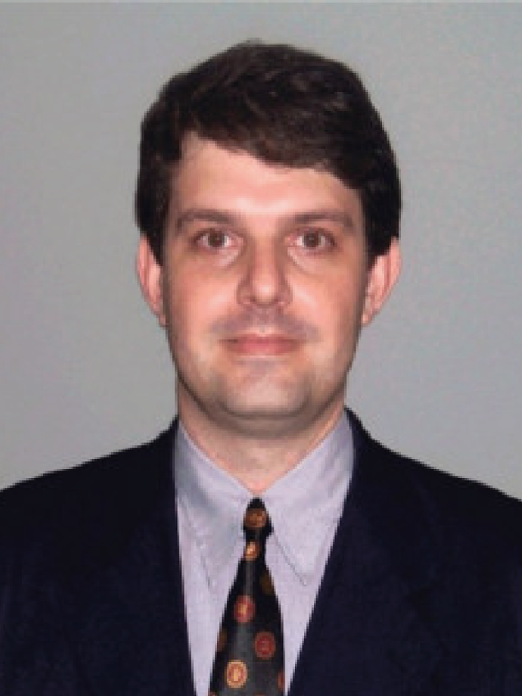 White male with short black hair, using square shaped glass