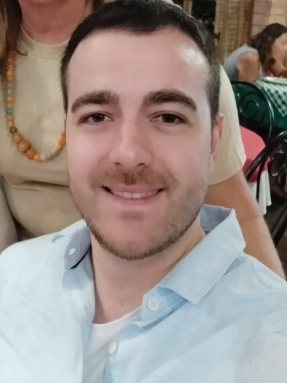 Homem, branco, cabelos castanhos e camisa azul claro.